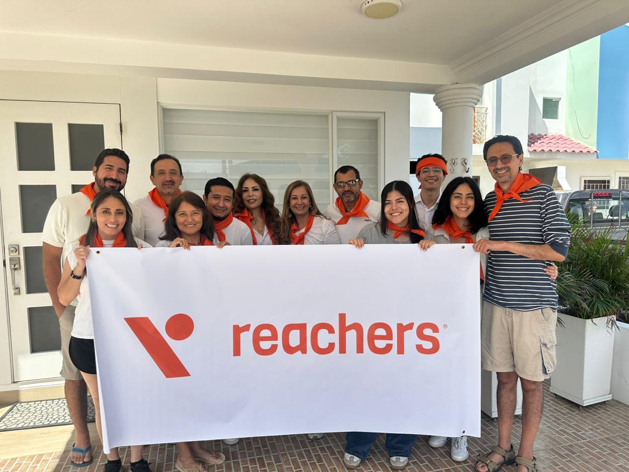 Equipo de Reachers Services sosteniendo el banner de la marca